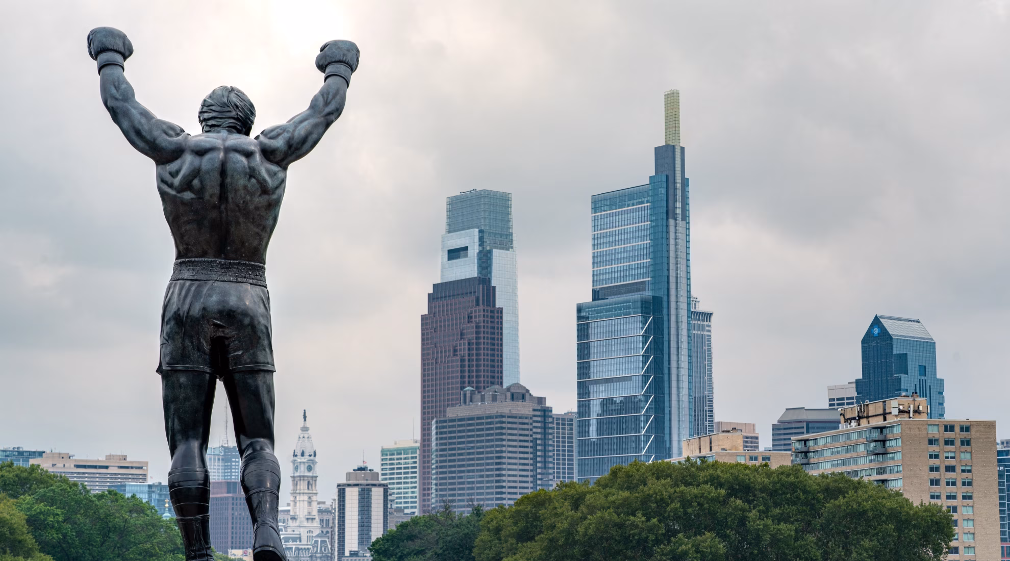 Estatua de Rocky Balboa con los brazos levantados contra el horizonte de Filadelfi