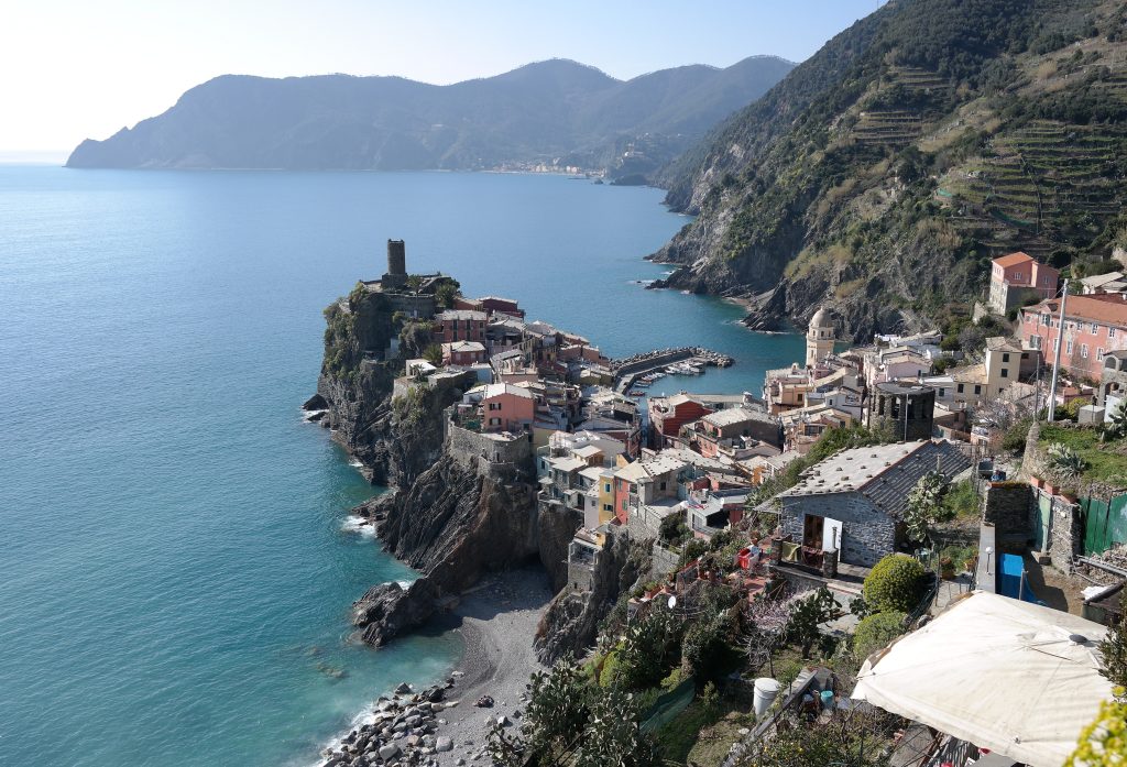 Pueblo de casas de colores sobre un promontorio junto al mar, en la costa de Liguria